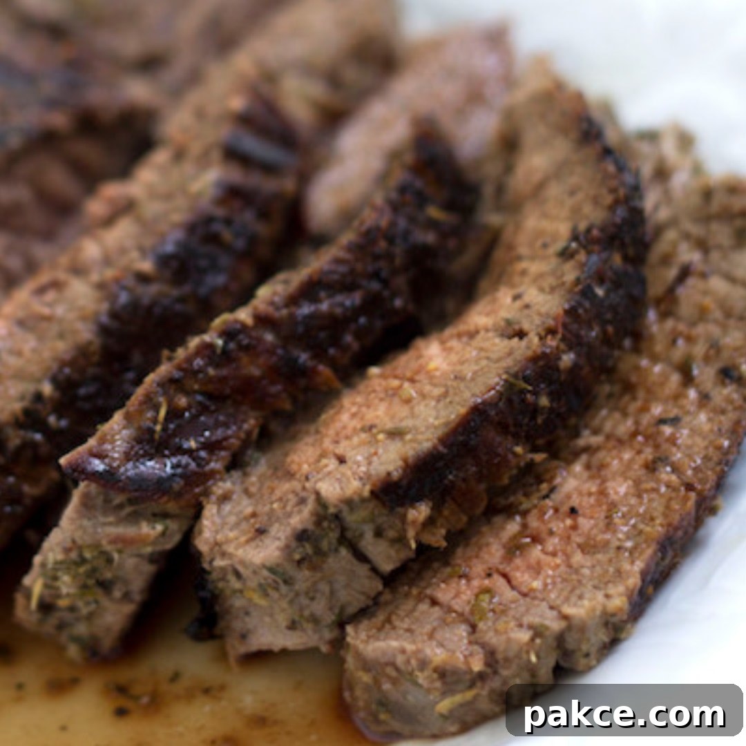 Perfectly grilled and seasoned Italian flank steak, thinly sliced against the grain, resting on a plate with its natural juices