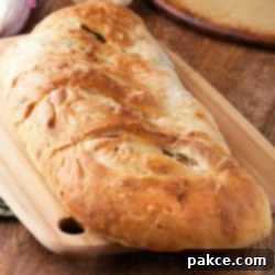 Garden Veggie Stromboli 3 Vegetable Stromboli on a cutting board, ready to be sliced and served with a side of marinara sauce.
