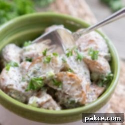 Roasted Red Potato Delight 3 Bowl of potato salad garnished with parsley with a fork