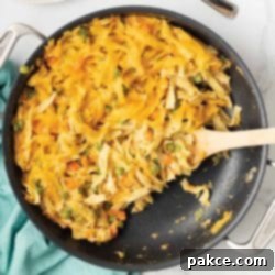Golden Cheesy Tuna Delight 8 A golden-brown cheesy tuna casserole in a skillet, topped with melted cheddar cheese and fresh parsley garnish.
