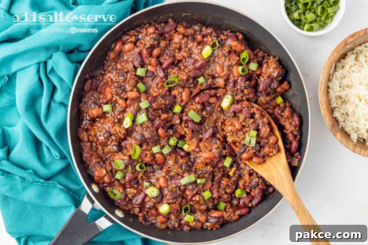 30-Minute BBQ Beef and Beans 6 Beef and beans garnished with green onion in a skillet with a wooden spoon.