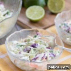 Fiesta Cole Slaw 3 Close-up of Tex-Mex Cole Slaw in a white bowl with fresh lime and cilantro