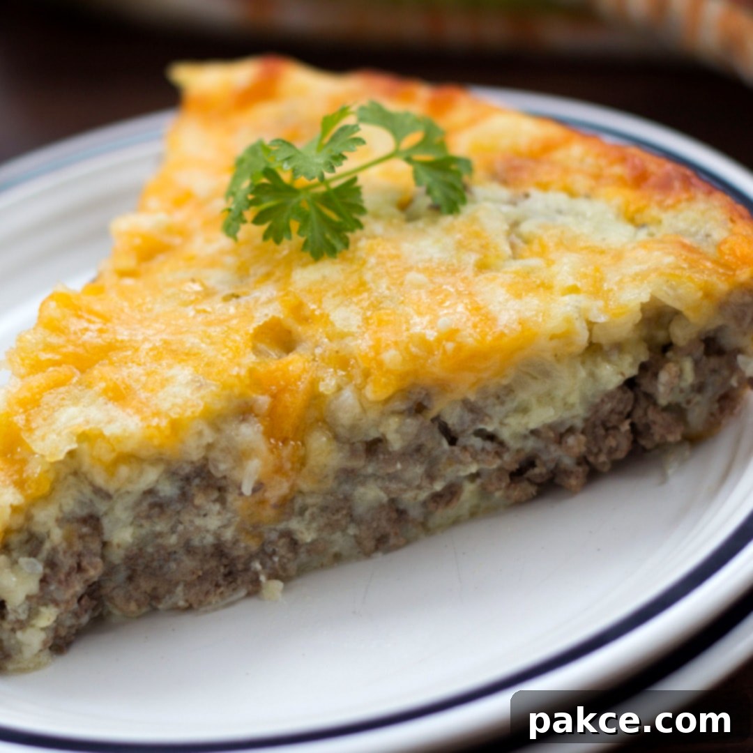 White plate with slice of cheeseburger pie and sprig of parsley