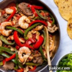 Texas Fajitas 5 Sizzling pan of Texas Fajitas with beef, chicken, and shrimp, ready to be served