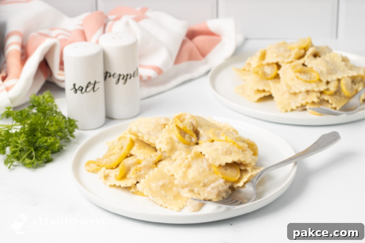Two plates of Cheese Ravioli with Summer Squash with a creamy sauce with salt and pepper shakers and sprigs of parsley.