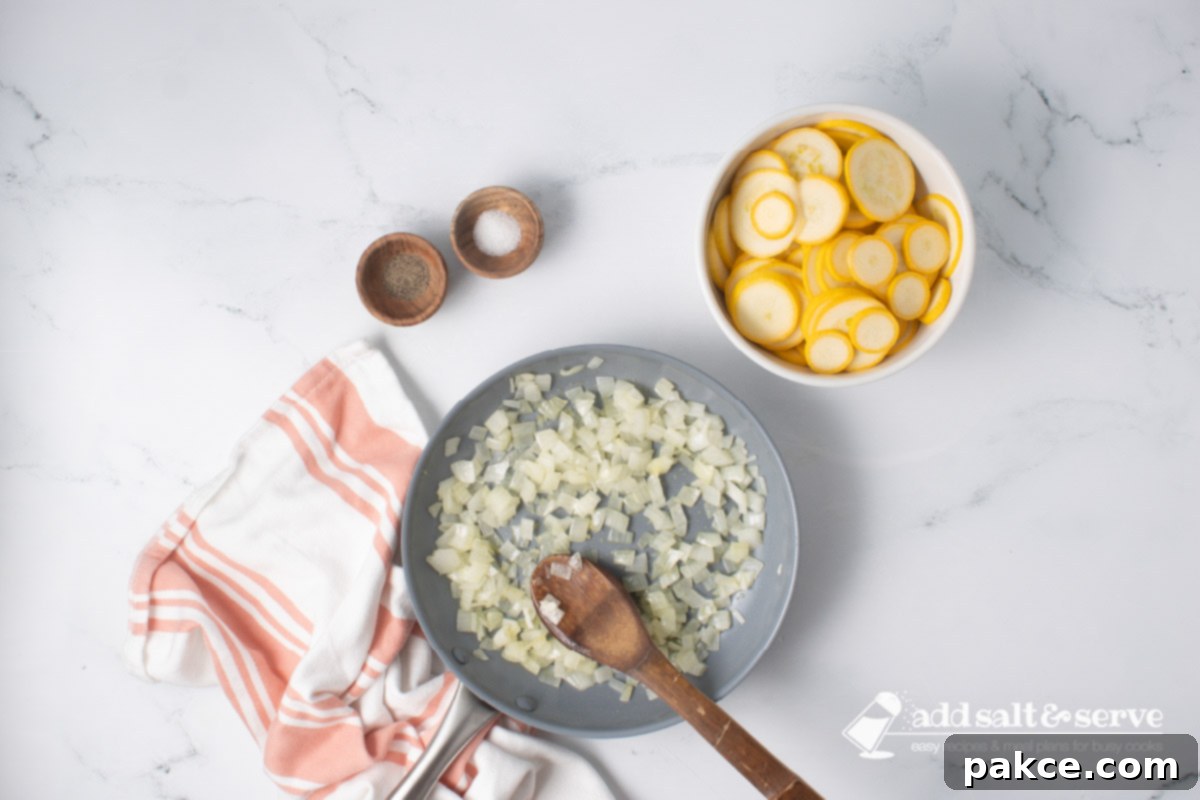 20-Minute Velvety Summer Squash Ravioli 5 Chopped onion being sautéed in a skillet with a wooden spoon beside a bowl of sliced yellow squash and small bowls of salt and pepper.