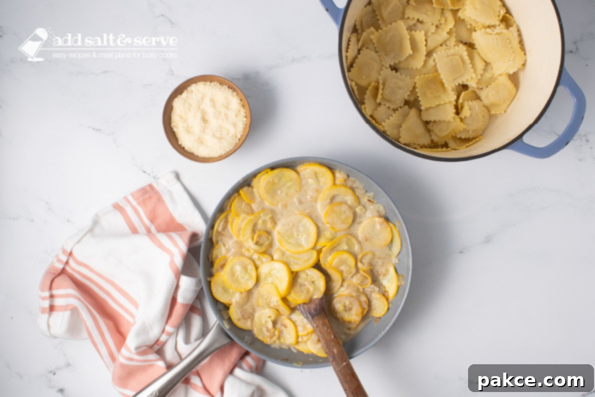 20-Minute Velvety Summer Squash Ravioli 8 Skillet of sautéed yellow squash and onion after cooking with mixture of milk, flour, and butter beside a pot of cooked cheese ravioli, and a small bowl of Parmesan cheese.