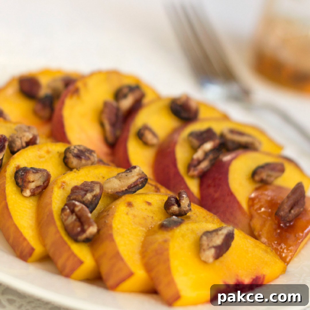 White plate with peach slices topped with chopped pecans. 