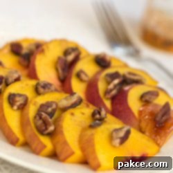 Golden Peach & Nut Bliss 3 White plate with peach slices topped with chopped pecans.